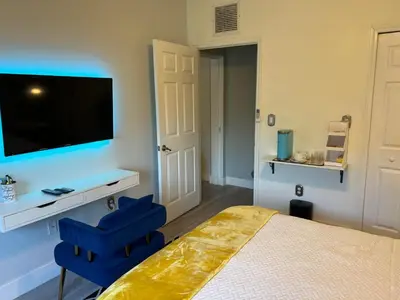 a bedroom with a bed and two blue chairs at Chic Private Retreat in Homestead