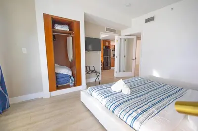 a bedroom with a bed with a blue and white striped blanket at King 1 Bed Apt with rooftop pool C202 in Miami Beach