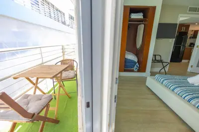 a balcony of a cruise ship with a table and a bed at King 1 Bed Apt with rooftop pool C202 in Miami Beach