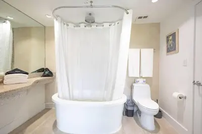 a white bathroom with a shower and a toilet at King Bed-Apt with Rooftop Pool-Bar D303 in Miami Beach