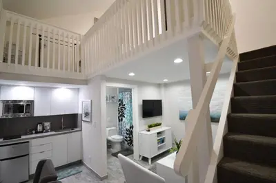 a living room with a staircase and a kitchen at Modern Loft wsteps to Beach Kitchenette in Hollywood