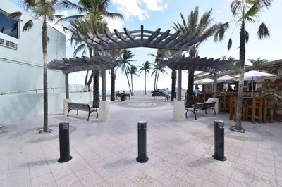 a pavilion with benches and palm trees next to the beach at Modern Loft wsteps to Beach Kitchenette in Hollywood