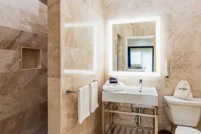 a bathroom with a sink and a toilet and a mirror at The Link Hotel South Beach in Miami Beach