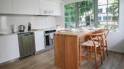 a kitchen with a wooden table and chairs in it at Beach Haus Design District in Miami