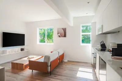 a white living room with a couch and a tv at Beach Haus Design District in Miami