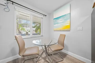 a dining room with a glass table and two chairs at Riverbend Apartments by Lowkl in Fort Lauderdale