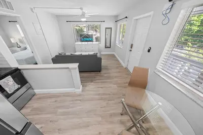 a living room with white walls and wood floors at Riverbend Apartments by Lowkl in Fort Lauderdale