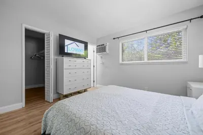 a bedroom with a bed and a flat screen tv at Riverbend Apartments by Lowkl in Fort Lauderdale