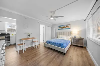 a bedroom with a bed and a table and a kitchen at Riverbend Apartments by Lowkl in Fort Lauderdale