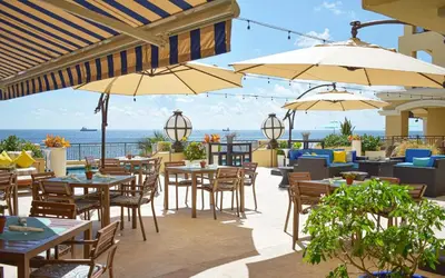 an outdoor patio with tables and chairs and umbrellas at Private Residences at The Atlantic Resort & Spa in Fort Lauderdale