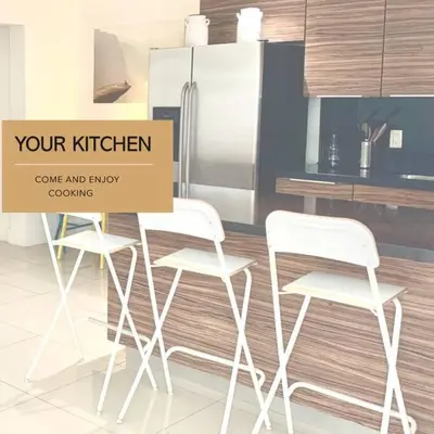 a kitchen with three white chairs and a refrigerator at GroveO5 10 minutes from Miami Beach in Miami