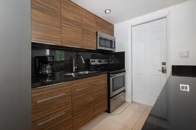 a kitchen with wooden cabinets and a sink at GroveO5 10 minutes from Miami Beach in Miami