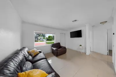 a living room with a leather couch and a chair at Casa Neisy Florida 10 minutes from Hollywood Beach and Hard Rock Hotel & Casino Hollywood in Hollywood