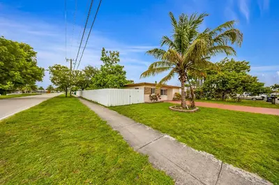a house on a street with a palm tree and a sidewalk at Casa Neisy Florida 10 minutes from Hollywood Beach and Hard Rock Hotel & Casino Hollywood in Hollywood
