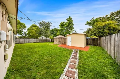 a backyard with a tiny house on the grass at Casa Neisy Florida 10 minutes from Hollywood Beach and Hard Rock Hotel & Casino Hollywood in Hollywood