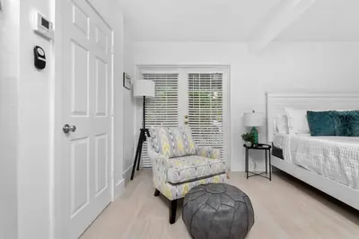 a bedroom with a bed and a chair and a door at The Riverside Retreat 1 in Fort Lauderdale