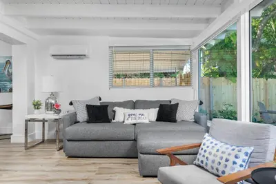 a living room with a gray couch and chairs at The Riverside Retreat 2 in Fort Lauderdale