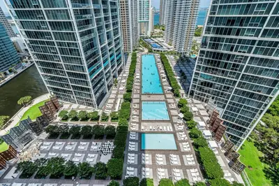 an aerial view of a pool between two tall buildings at ICON Brickell Miami- 2 bedroom Condo with City and water views! in Miami