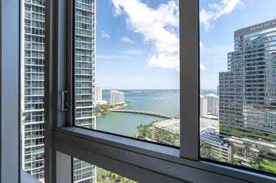 a window with a view of a river and buildings at ICON Brickell Miami- 2 bedroom Condo with City and water views! in Miami