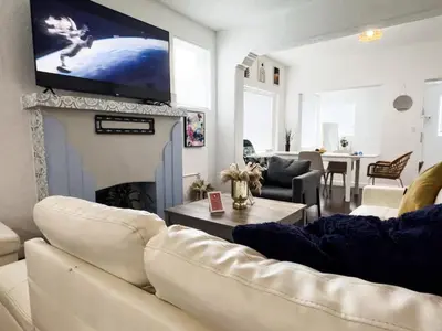 a living room with a couch and a tv above a fireplace at Dos Casitas Design District #1 - 3 Bedroom House in Miami