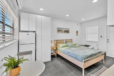 a bedroom with a bed and a table and a refrigerator at Beachfront & Pool Near Marriott Hollywood Beach in Hollywood