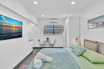 a bedroom with a large bed and a table at Beachfront & Pool Near Marriott Hollywood Beach in Hollywood