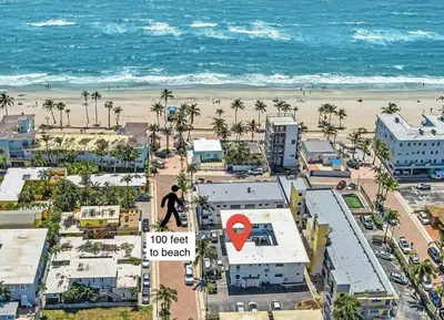 a person walking on a sign next to the beach at Beachfront & Pool Access Unit W 2 Queen Beds in Hollywood