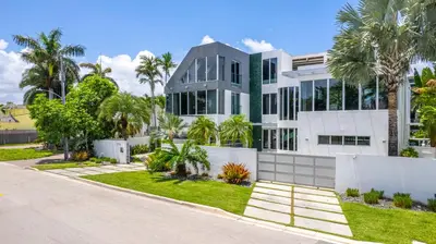 a large white building with palm trees in front of it at Villa Seminole in Fort Lauderdale