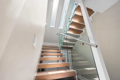 a staircase with glass railings and wooden stairs at Villa Seminole in Fort Lauderdale