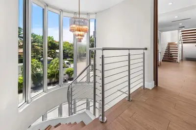 a staircase in a house with windows and a chandelier at Villa Seminole in Fort Lauderdale