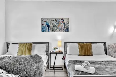 a bedroom with two beds and a stuffed animal on a chair at Studio Retreat With 2 Queen Beds Hollywood Blvd in Hollywood