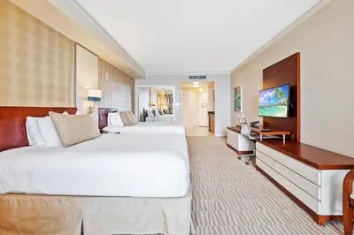 a hotel room with two beds and a desk at Trump International Beach Resort Deluxe 2 Queen Ocean Front in Sunny Isles Beach