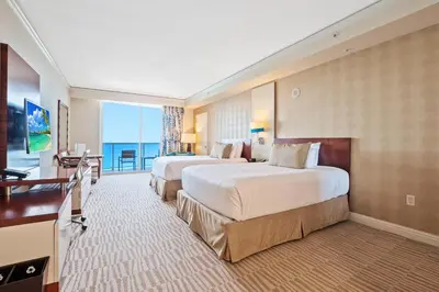 a hotel room with two beds and a balcony at Trump International Beach Resort Deluxe 2 Queen Ocean Front in Sunny Isles Beach