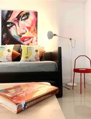 a living room with a couch with a painting on the wall at GroveO4 10 min from the Beach in Miami