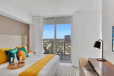 a bedroom with a bed and a desk and a window at Front Intercostal Luxury Apt View Amazing in Hollywood