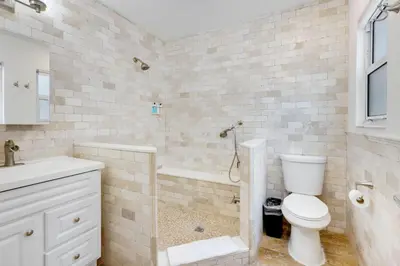 a white bathroom with a toilet and a sink at ULTRA chic apartment steps from the beach in Hollywood
