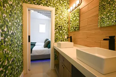 a bathroom with a sink and a mirror and a bed at LuxOasis Getaway Minigolf, Pool, Beach, Chess, Jacuzzi in Tamiami