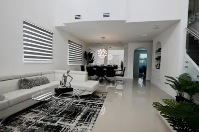 a living room with a white couch and a table at LuxOasis Getaway Minigolf, Pool, Beach, Chess, Jacuzzi in Tamiami