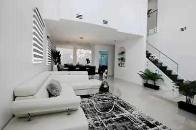 a living room with white furniture and a staircase at LuxOasis Getaway Minigolf, Pool, Beach, Chess, Jacuzzi in Tamiami
