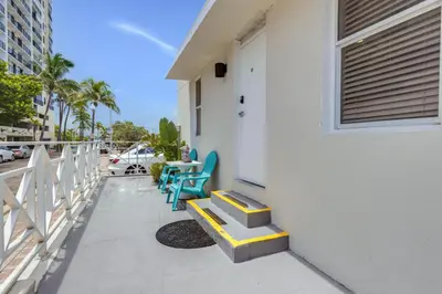 a porch with two blue chairs and a door at ULTRA Modern Apartment by the Beach in Hollywood
