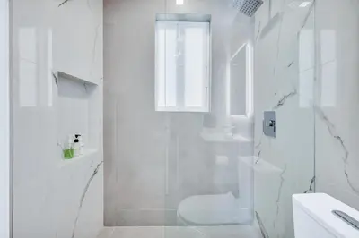 a white bathroom with a shower and a toilet at ULTRA Modern Apartment by the Beach in Hollywood