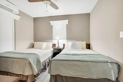 two beds in a room with white walls at ULTRA magical apartment at the Beach in Hollywood
