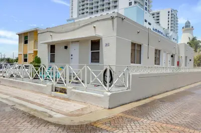 a white building with a fence on a street at ULTRA magical apartment at the Beach in Hollywood