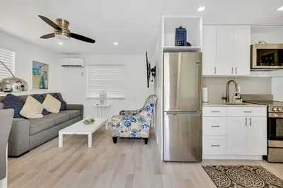 a kitchen and living room with a stainless steel refrigerator at ULTRA spacious apartment steps from the beach in Hollywood