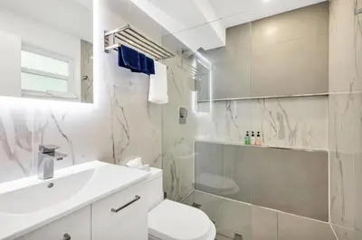 a white bathroom with a toilet and a sink at ULTRA exciting apartment at the Boardwalk in Hollywood