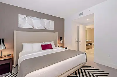 a bedroom with a large white bed with a red pillow at Luxury 2 Br Oceanfront Balcony Beautiful Amenities in Hollywood