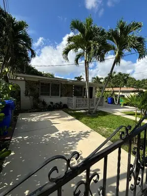a house with palm trees in front of a walkway at LaBella Suite in Miami