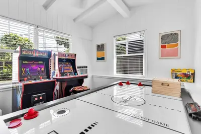 a gaming room with a table and arcade games at Ventur Tropical with Elite Pool & Ultimate Fun Zone in Fort Lauderdale