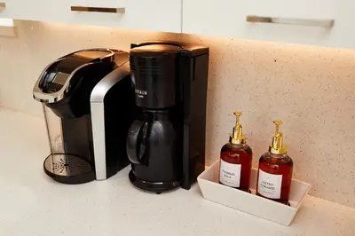 a coffee maker and two bottles on a counter at Private Villa Miami Pool Oasis in Miami