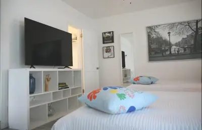 a white room with a tv and a bed with a pillow at B01 Minutes from the beach Studio Midtown Wynwood in Miami